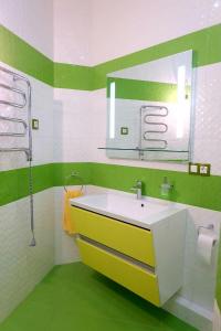 a green and white bathroom with a sink and a mirror at Золотой Бугаз in Gribovka