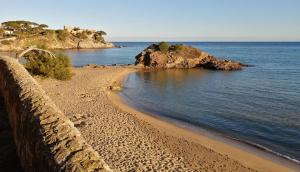 una playa con una pared de retención y el océano en Hotel Ancora, en Palamós