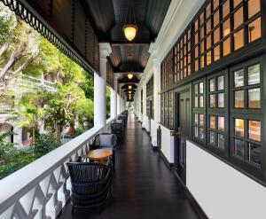 
a room with a lot of windows and benches at Raffles Singapore in Singapore
