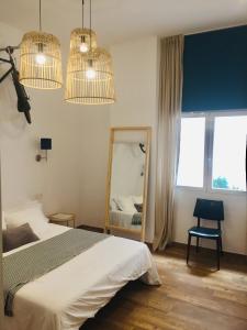 sypialnia z łóżkiem, lustrem i światłami w obiekcie Sunny Stay Guest Houses w Alicante