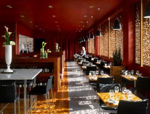 a row of tables in a restaurant with red walls at Radisson Blu Hotel, Liverpool in Liverpool