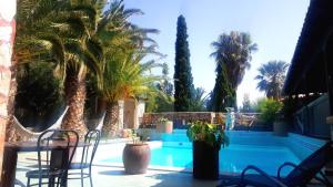 - une piscine bordée de palmiers, d'une table et de chaises dans l'établissement Sagittarius Home, à Arico Viejo