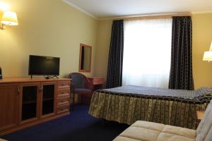 une chambre d'hôtel avec un lit et une télévision dans l'établissement Kristall Hotel, à Dmitrov