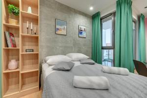 een slaapkamer met een groot bed en groene gordijnen bij Grand Apartments - Garden Gates in Gdańsk