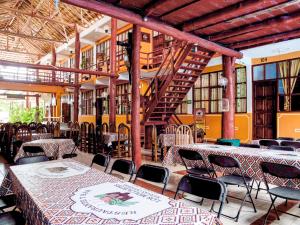 a restaurant with tables and chairs in a building at Hotel Bello Caribe in Cozumel