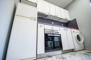 a kitchen with a stove and a washer and dryer at Huge Stylish Apartment Monroe 1 / City Centre in Plovdiv