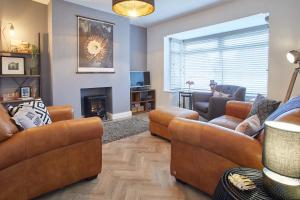 a living room with leather furniture and a fireplace at Host & Stay - Willow View in Saltburn-by-the-Sea