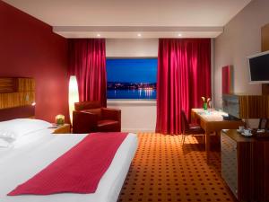 a hotel room with a bed and a desk and a window at Radisson Blu Hotel, Liverpool in Liverpool