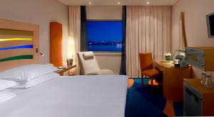 a hotel room with a bed and a desk and a window at Radisson Blu Hotel, Liverpool in Liverpool
