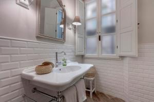 un bagno bianco con lavandino e specchio di Lambert Apartment a Firenze Altre 16 foto