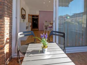 un tavolo con due sedie e un vaso di fiori sopra di Apartment Sants-Les Corts Galileu by Interhome a Barcellona