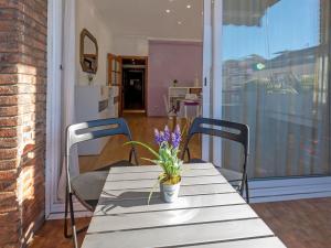 - une table avec deux chaises et un vase de fleurs dans l'établissement Apartment Sants-Les Corts Galileu by Interhome, à Barcelone