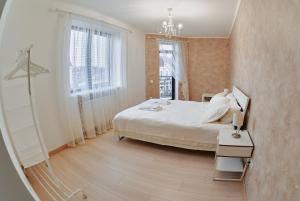 a bedroom with a large bed and a chandelier at City centre apartment in Kolomyya