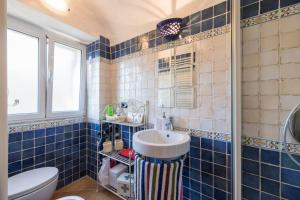 baño de azulejos azules con lavabo y aseo en La Casa di Sandra a Noli en Noli