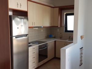 a kitchen with a stainless steel refrigerator and white cabinets at Sea Flower Villa Bali Crete in Vlikhádha