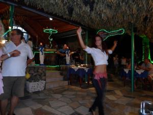 a woman dancing in front of a group of people at Sea Flower Villa Bali Crete in Vlikhádha