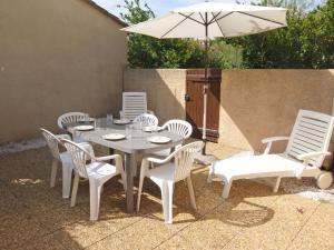 a white table and chairs with an umbrella at Holiday Home Les Capellanes by Interhome in Saint-Cyprien-Plage