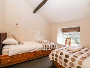 a bedroom with two beds and a window at The Cottage Glossop in Glossop