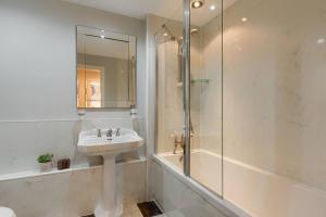 a white bathroom with a sink and a shower at 45 Guthrie Court, Fantastic top floor apartment next to Gleneagles in Auchterarder +11 photos