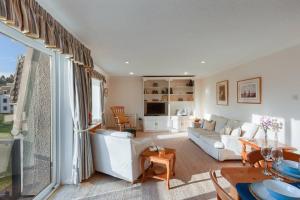 a living room with white furniture and a large window at 45 Guthrie Court, Fantastic top floor apartment next to Gleneagles in Auchterarder