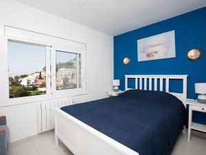 Cañet de MarにあるApartment Cala Salionc by Interhomeの青と白のベッドルーム(ベッド1台、窓付)