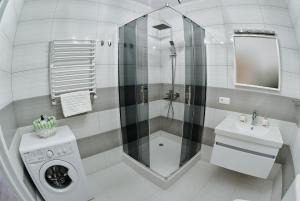 a white bathroom with a shower and a washing machine at City centre apartment in Kolomyya +31 photos