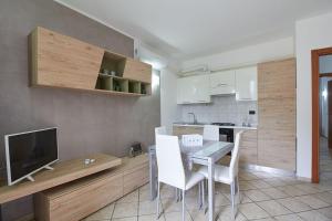 Appartamento Ulivo في فينالي ليغوري: مطبخ وغرفة طعام مع طاولة وكراسي