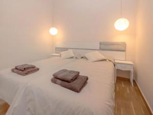 ein weißes Bett mit zwei Handtüchern darüber in der Unterkunft Apartment Eixample Esquerre Arago Rocafort by Interhome in Barcelona