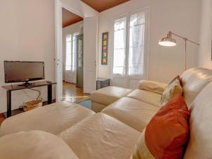 a living room with a white couch and a tv at Apartment Eixample Esquerre Arago Rocafort by Interhome in Barcelona