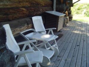 due sedie bianche sedute su un portico di una cabina di Holiday Home Veijon kelo by Interhome a Korpilahti