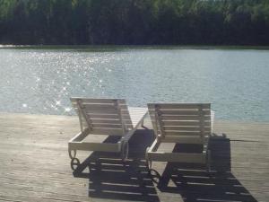 due sedie sedute su un molo vicino a un lago di Holiday Home Veijon kelo by Interhome a Korpilahti