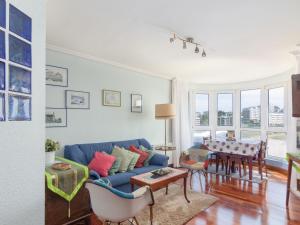 a living room with a blue couch and a table at Apartment Rico by Interhome in Castro-Urdiales