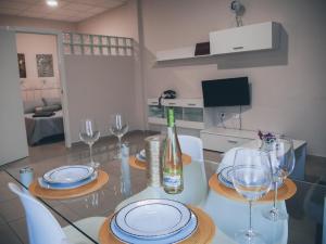 una mesa de comedor con copas y una botella de vino en Apartamentos Centro Emérita, en Mérida