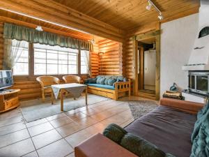 a log cabin living room with a couch and a tv at Holiday Home Kallionnenä by Interhome in Mäkikylä