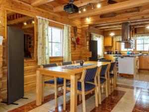 uma cozinha com uma mesa de madeira e cadeiras em Holiday Home Valkonen pohjonen a by Interhome em Levi