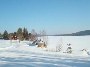 une route enneigée à côté d'une masse d'eau dans l'établissement Holiday Home Raanumökki 1 by Interhome, à Lampsijärvi