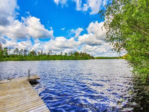 un quai sur un lac avec des arbres et un ciel nuageux dans l'établissement Holiday Home Rinne-expertti by Interhome, à Torsansalo