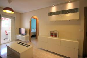 uma sala de estar com uma mesa e uma televisão em Apartamento CasaTuris en Playa Lisa Santa Pola SP101 em Santa Pola