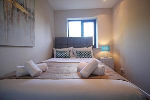 a bedroom with a large bed with pillows and a window at The Barwoods - Modern Spacious Home in Chester - Parking in Chester