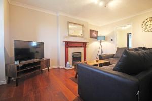 a living room with a couch and a fireplace at The Barwoods - Modern Spacious Home in Chester - Parking in Chester