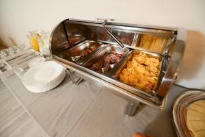 Garni Hotel Mediteraneo في نوفي ساد: طاولة مليئة بالحاويات من الطعام على منضدة