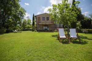 zwei Stühle im Gras vor einem Haus in der Unterkunft GHIZZOLO Residence - Refurbished 2024 in Montaione