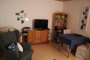 sala de estar con TV, silla y mesa en Michels Nest, en Stromberg