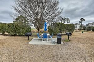 a table and chairs and a blue umbrella in a park at Magnolia Pointe Myrtle Beach Condo on Golf Course! in Myrtle Beach