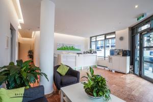 uma sala de estar em plano aberto com plantas e uma cozinha em Bayer's Boardinghouse und Hotel em Munique