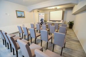 a room with chairs and a projection screen at Garni Hotel Mediteraneo in Novi Sad