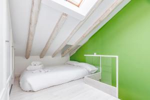 Un dormitorio con una pared verde y una cama en Fabuloso estudio en pleno centro de Madrid. en Madrid