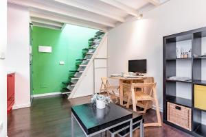 een woonkamer met een tafel en een trap bij Fabuloso estudio en pleno centro de Madrid. in Madrid