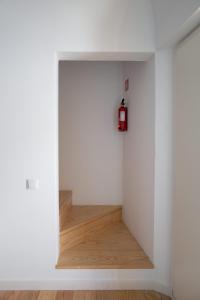 a hallway with white walls and a fire extinguisher on the wall at Casa da Travessa in Évora