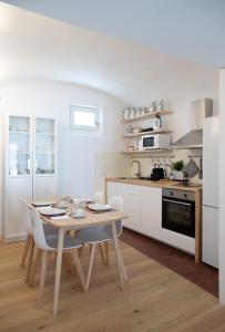 a kitchen with a wooden table and white appliances at Casa da Travessa in Évora